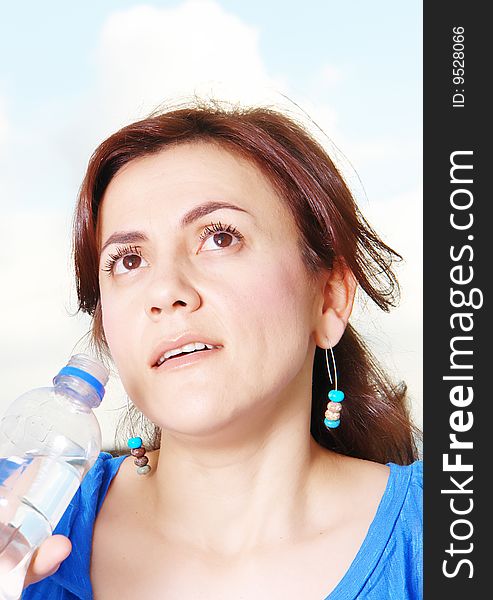 Young woman looking up and drinking water