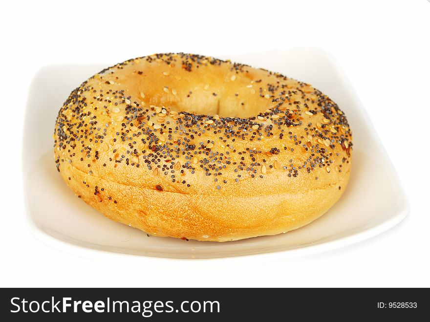 Bagel with sesame seeds on the plate isolated on the white.