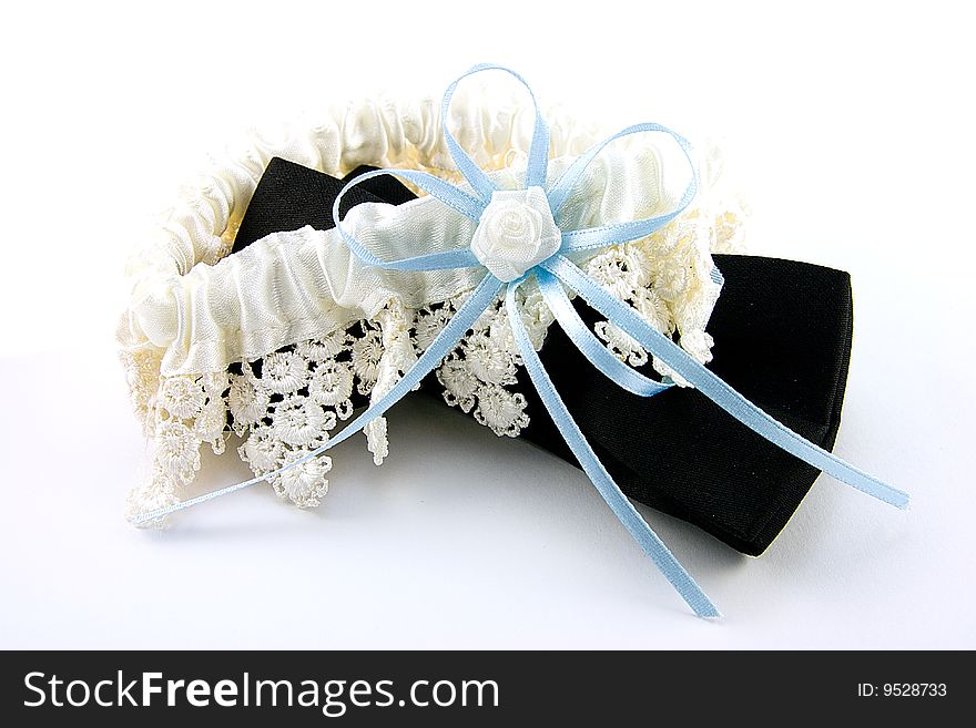 Black bow tie and white gartar with blue bow on a white background. Black bow tie and white gartar with blue bow on a white background