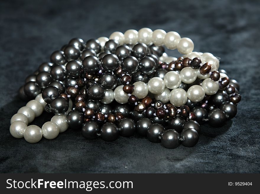 Three NECKLACES FROM pearls on a black velvet