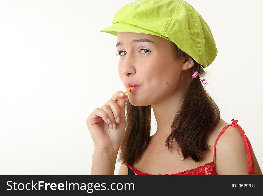 The girl in a green cap eats a sugar candy