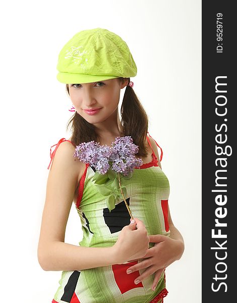 The girl in a green cap with a lilac bouquet