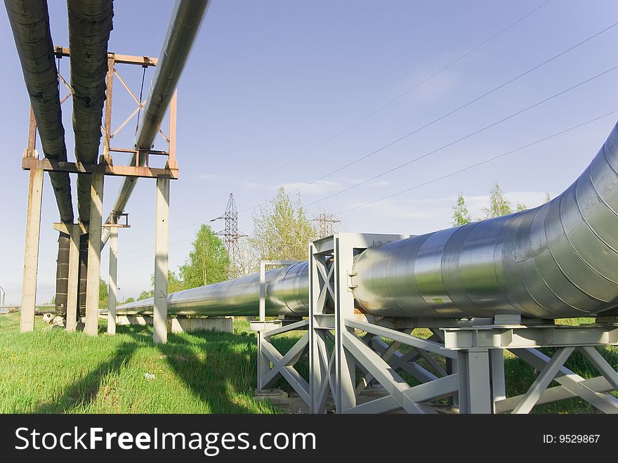 Industrial pipelines on pipe-bridge against blue sky. Industrial pipelines on pipe-bridge against blue sky.