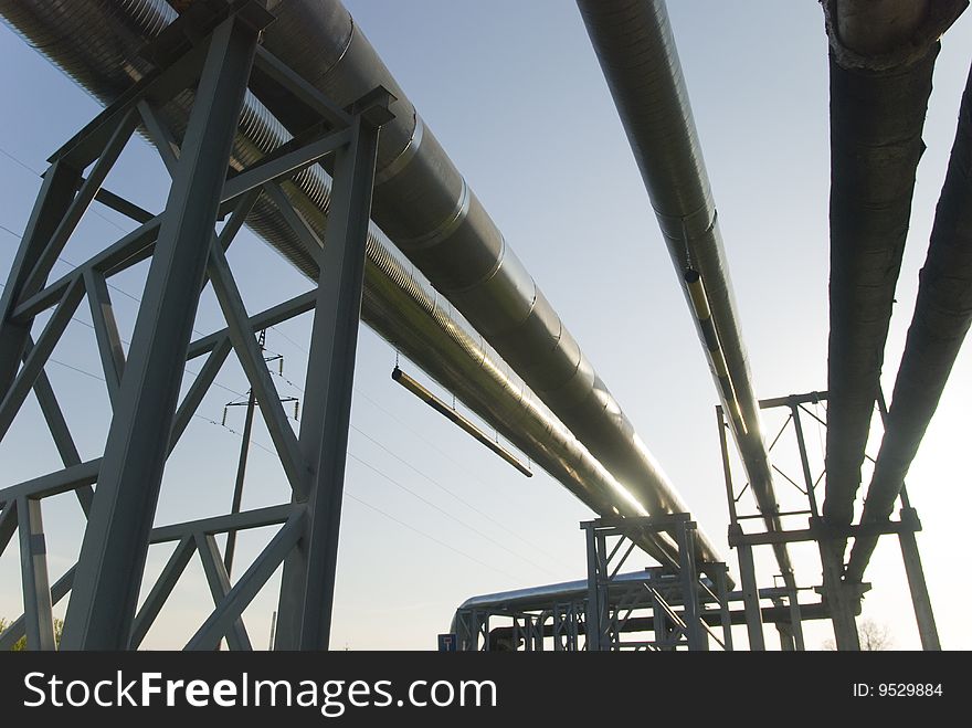Industrial pipelines on pipe-bridge against blue sky. Industrial pipelines on pipe-bridge against blue sky.