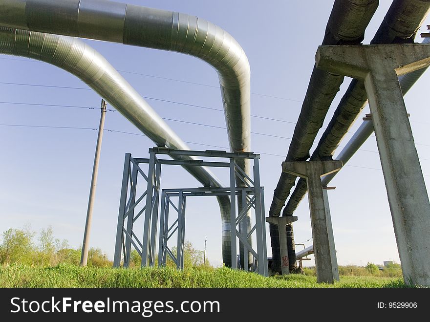 Industrial pipelines on pipe-bridge against blue sky. Industrial pipelines on pipe-bridge against blue sky.