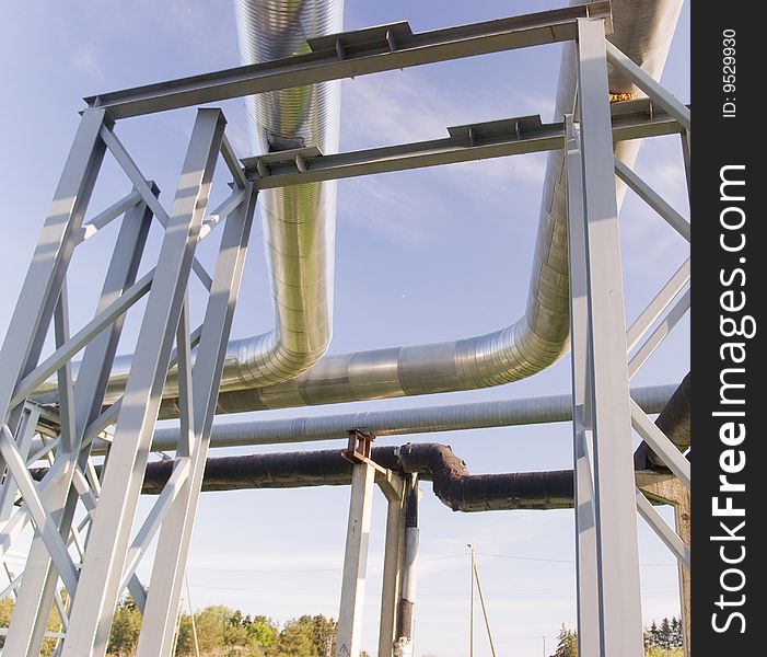 Industrial pipelines on pipe-bridge against blue sky. Industrial pipelines on pipe-bridge against blue sky.