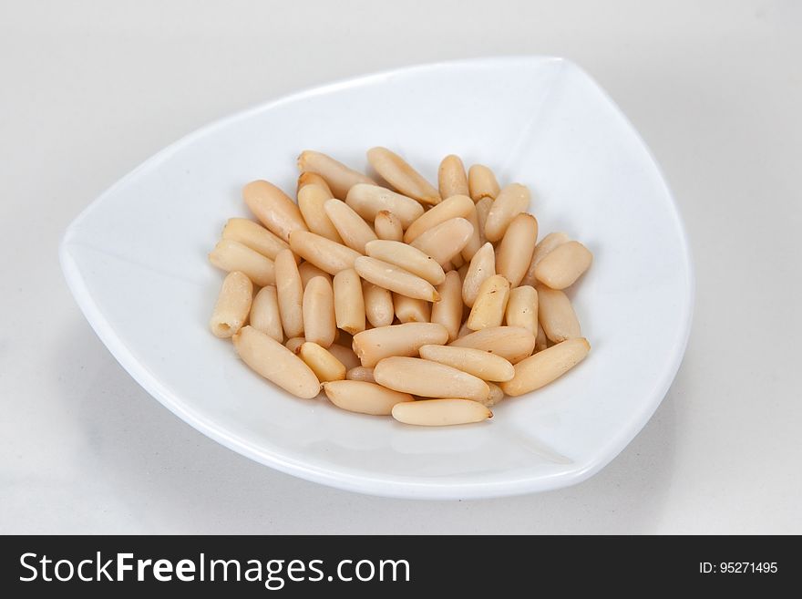Closeup of a dish of pine nuts.