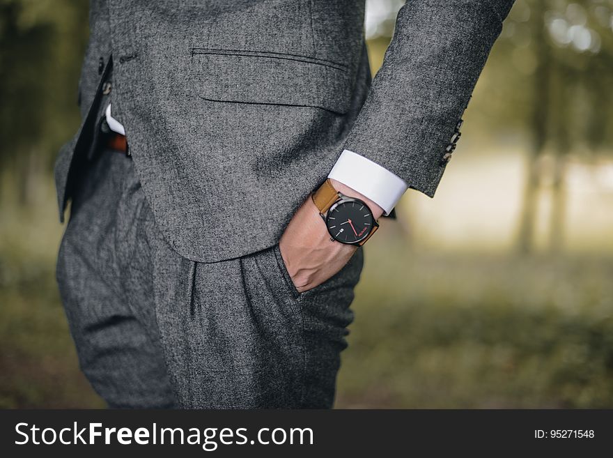 A businessman with a wristwatch holding his hand in the pocket. A businessman with a wristwatch holding his hand in the pocket.