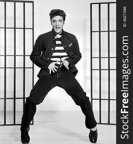 A black and white photo of Elvis Presley dancing in jail.