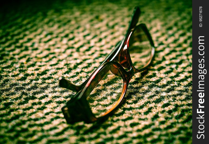 Close-up of eyeglasses with brown frame lying on a business carpet. Close-up of eyeglasses with brown frame lying on a business carpet.