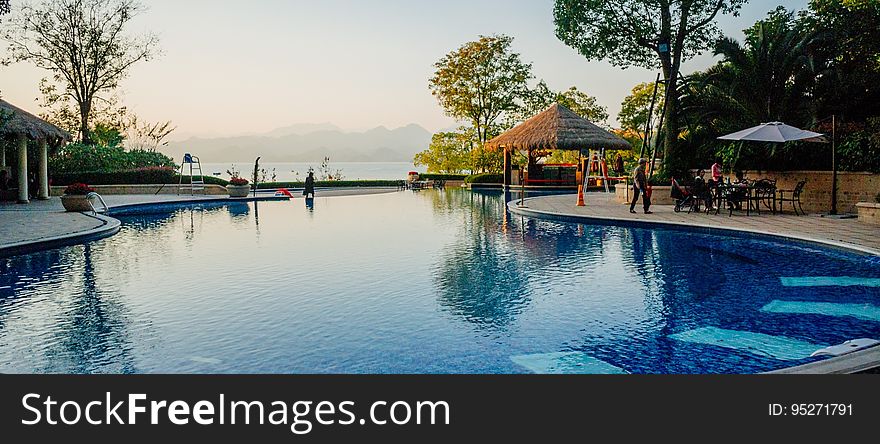 A luxury hotel swimming pool with a bar next to it.