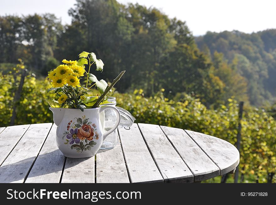 Flowers In Teapot On Table