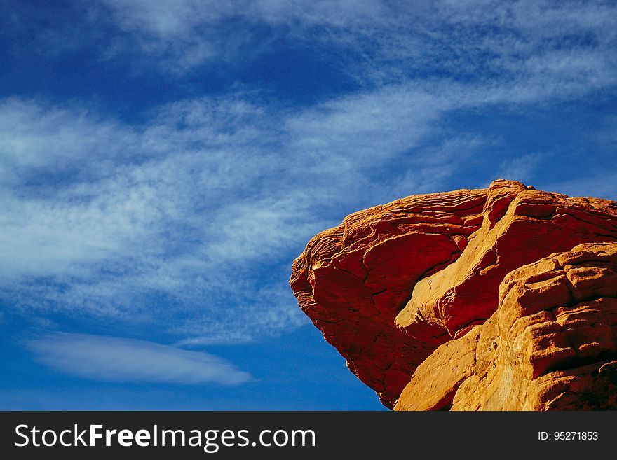 A sandstone rock with a blue sky in the background.