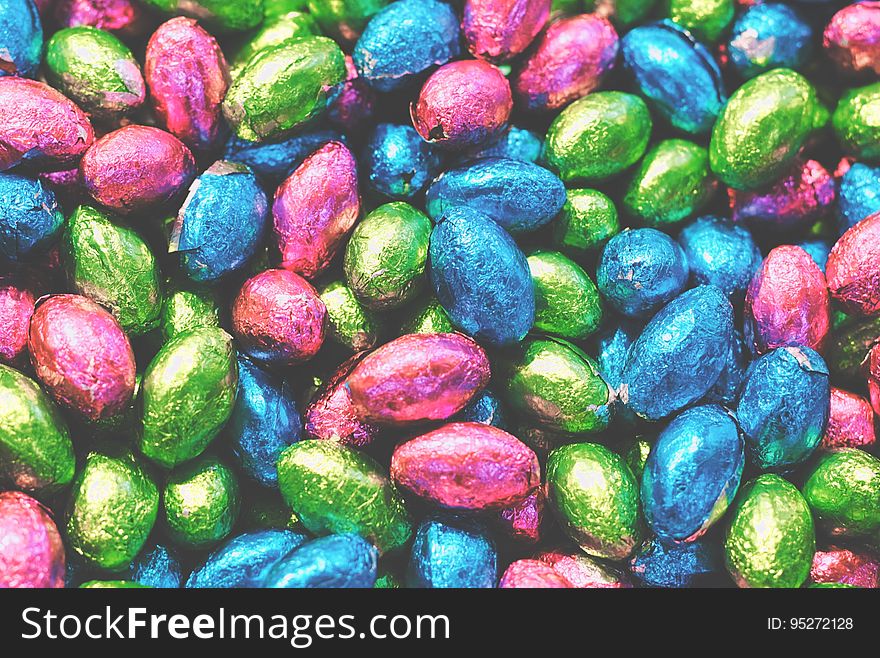 A pile of small chocolate eggs in colorful tinfoil wrappings. A pile of small chocolate eggs in colorful tinfoil wrappings.