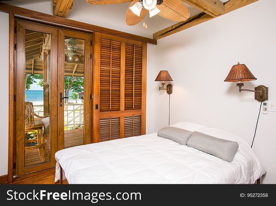 Interior of luxurious modern bedroom with glass doors and view of tropical beach,
