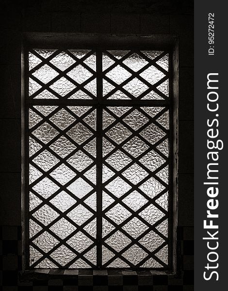 Metal bars over opaque glass windows in frame in black and white. Metal bars over opaque glass windows in frame in black and white.