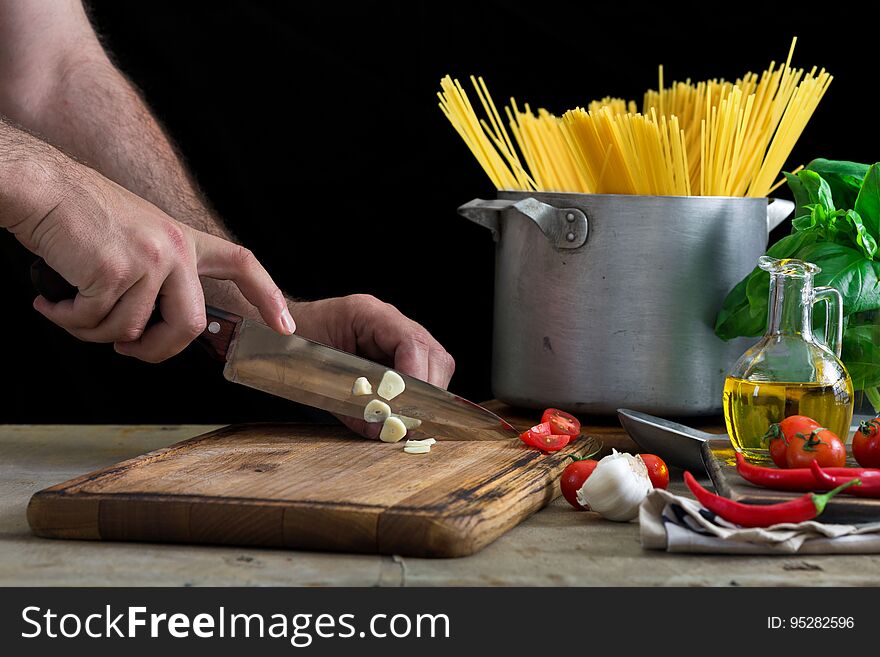 Man сooking an Italian pasta on light wooden table
