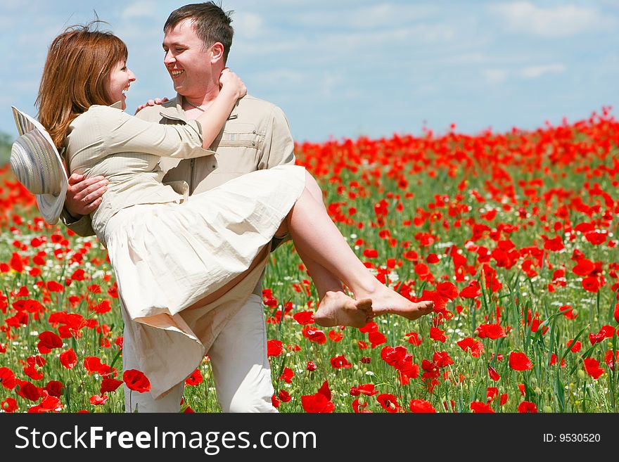 Couple on red poppies field