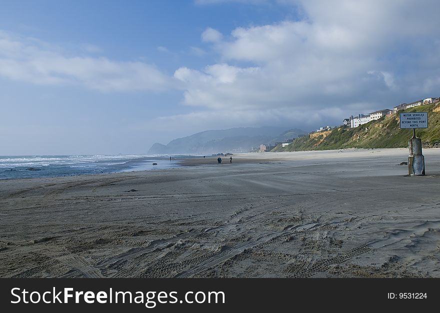 People beach combing in the distance on a beautiful day on the Oregon coast.