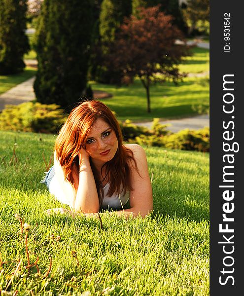 Beautiful red haired girl lying on the grass in an park and enjoying the
gorgeous sunset. Beautiful red haired girl lying on the grass in an park and enjoying the
gorgeous sunset.