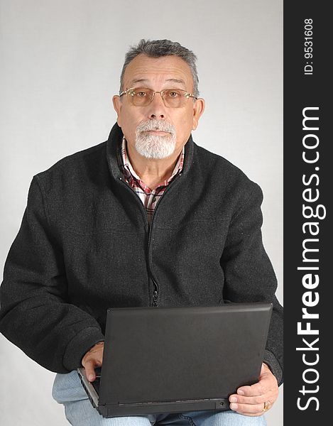 Senior with laptop computer isolated on grey background