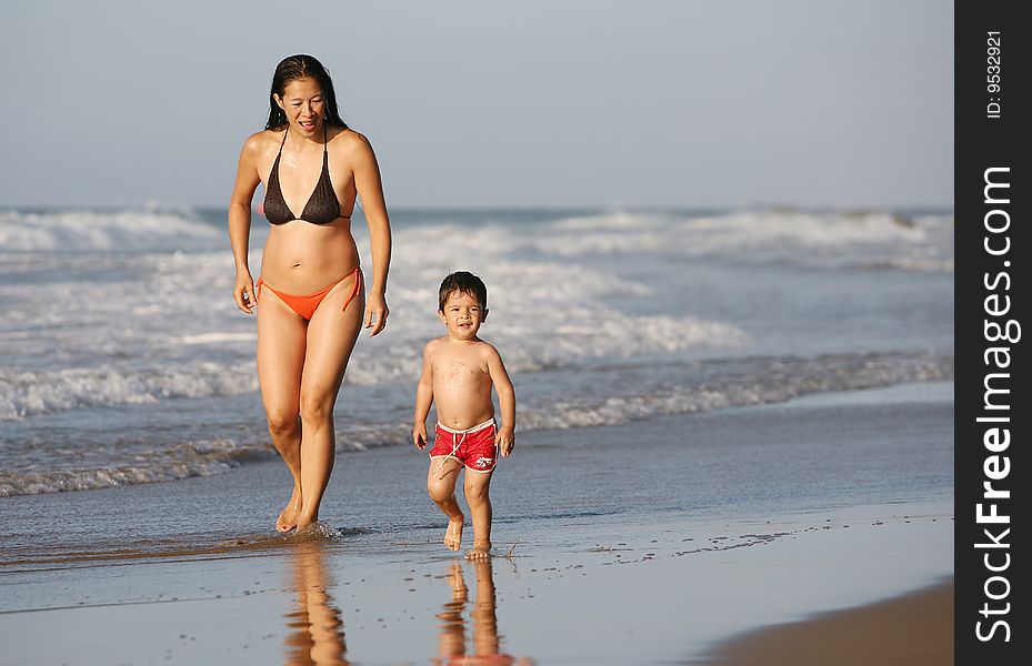 Mother and son running at the beach