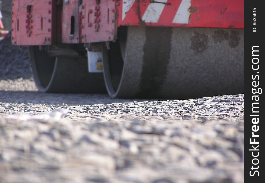 Big machine working on a stone road