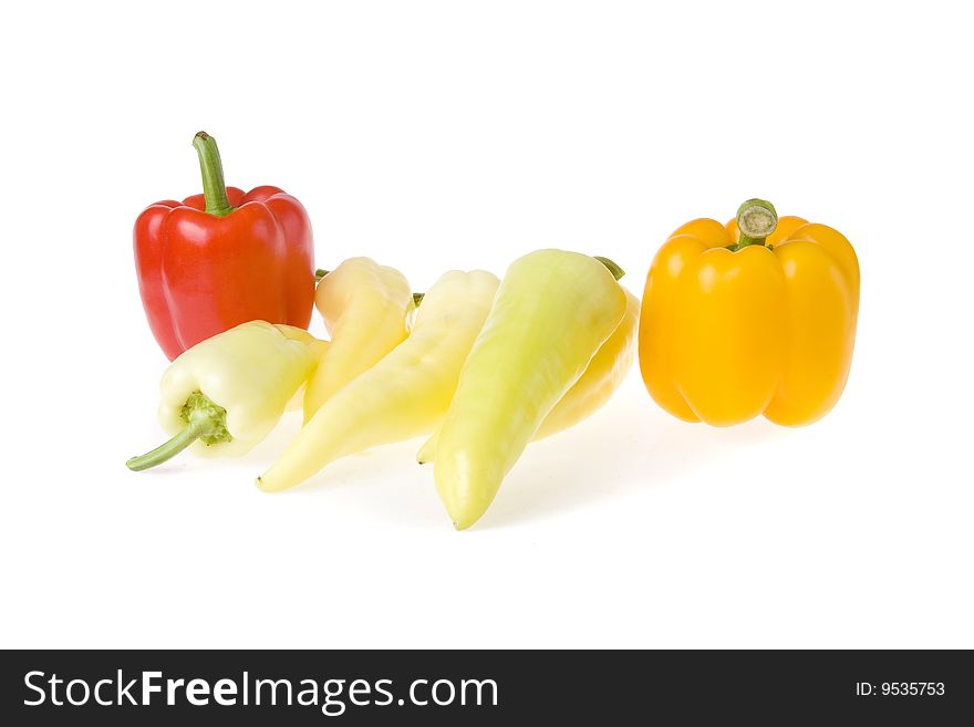 Red, orange and some white peppers on white ground. Red, orange and some white peppers on white ground
