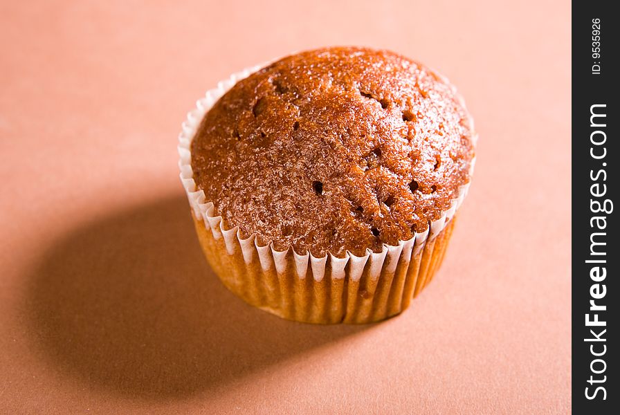 Chocolate muffin on brown background