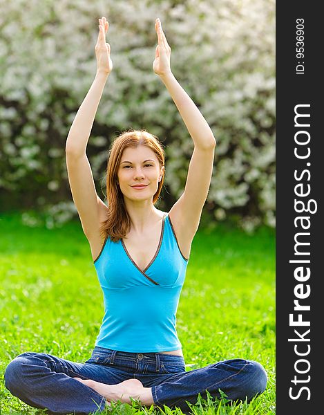 Beautiful young woman meditating outdoors