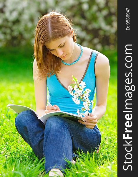 Pretty student with a flower studying outdoors. Pretty student with a flower studying outdoors