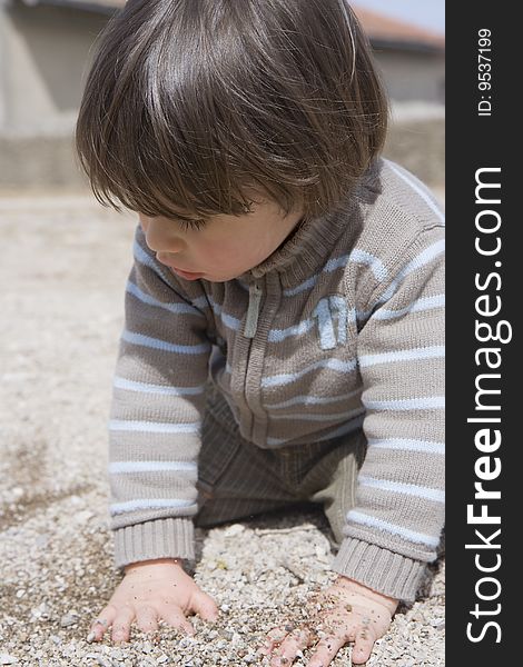 Small boy plaing alone in sand. Small boy plaing alone in sand