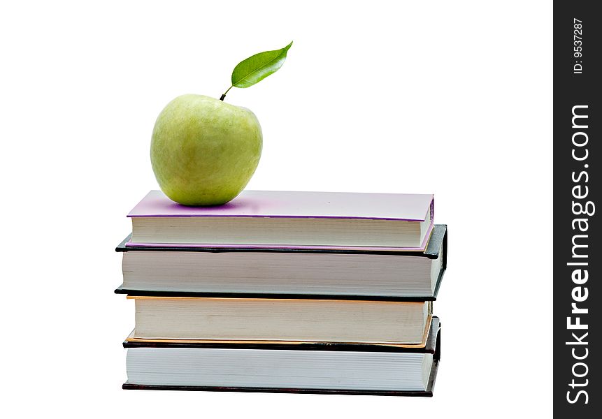 Green apple on pile of books on white background