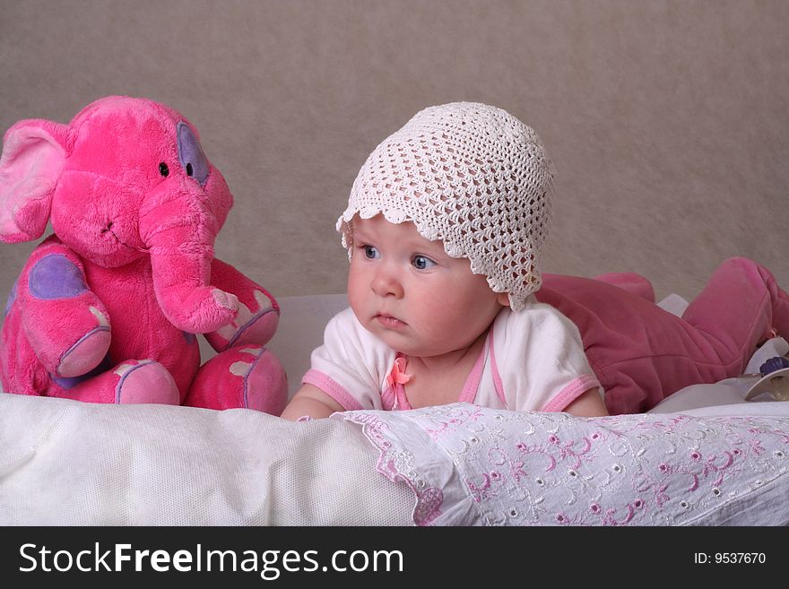 Sweet baby girl laying on a diaper with toy's elephant. Sweet baby girl laying on a diaper with toy's elephant