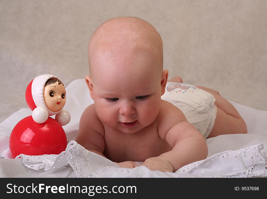 Curious 5 months old baby girl with toy on white background. Curious 5 months old baby girl with toy on white background