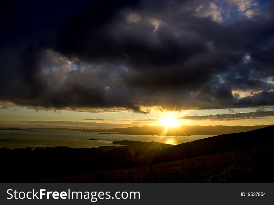 Horizon with sunset behind the mountains and the sea