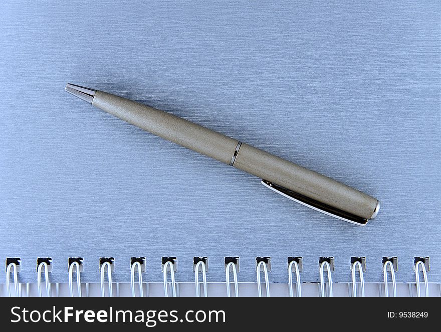 Silver pen on blue book