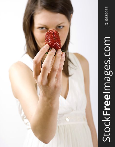 Woman holding a strawberry in front of her