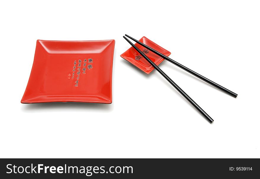 Chopsticks, red square plate and red saucer isolated