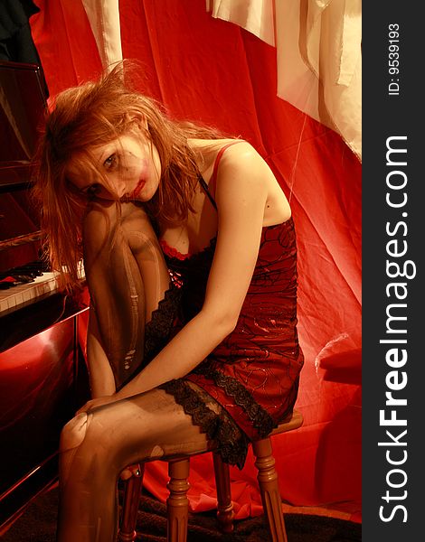 The woman in a red dress near to piano. The woman in a red dress near to piano