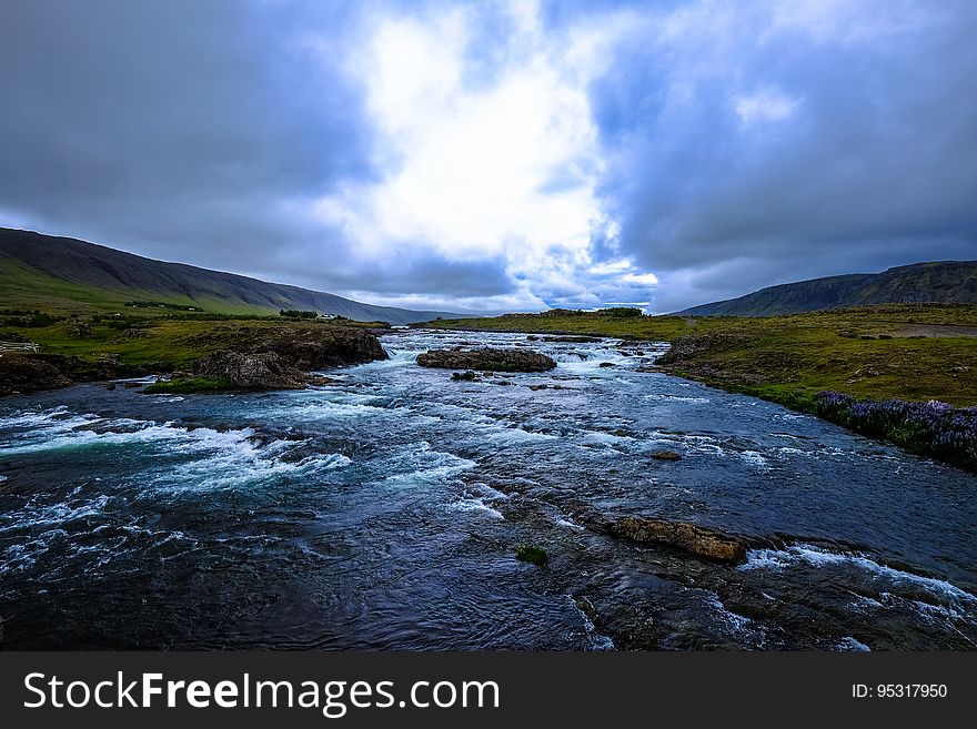 A river with rapids flowing through a valley. A river with rapids flowing through a valley.