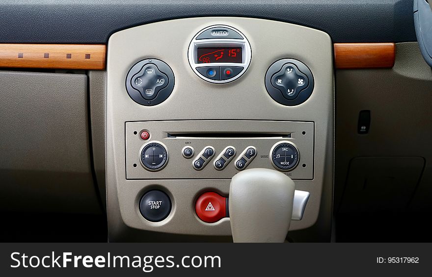 The central console of a car with media player and air conditioner controls. The central console of a car with media player and air conditioner controls.