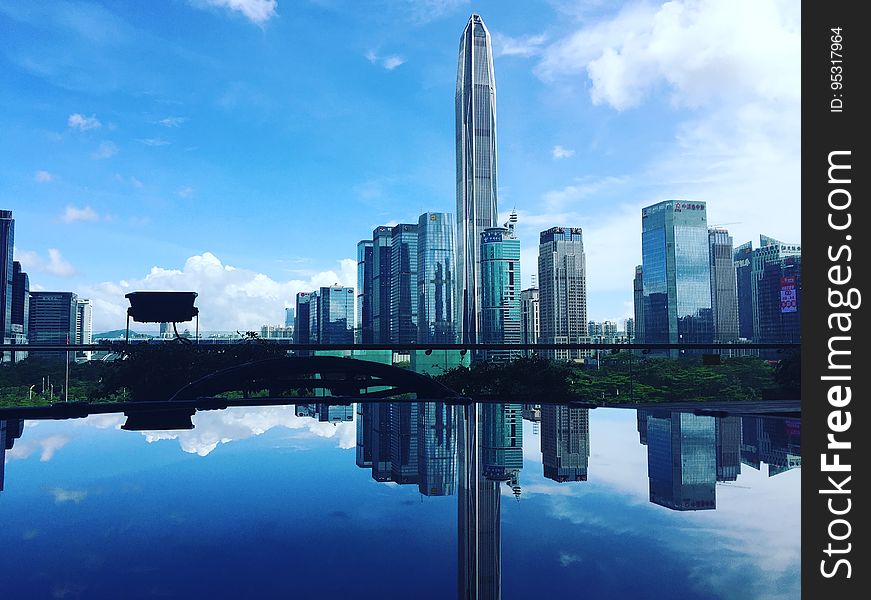 Modern skyscrapers reflecting on a still water surface. Modern skyscrapers reflecting on a still water surface.