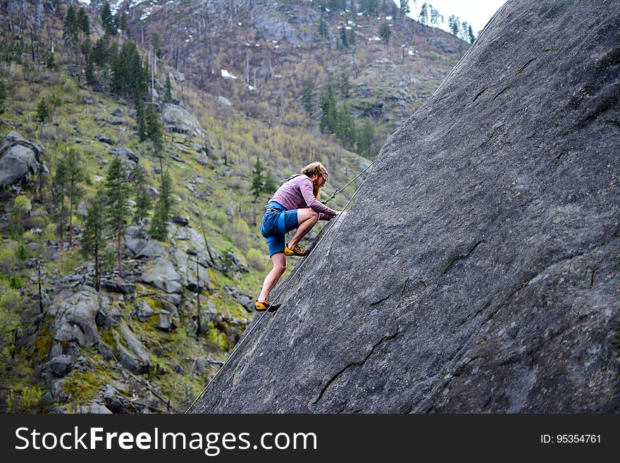 A man rock climbing on the mountains.