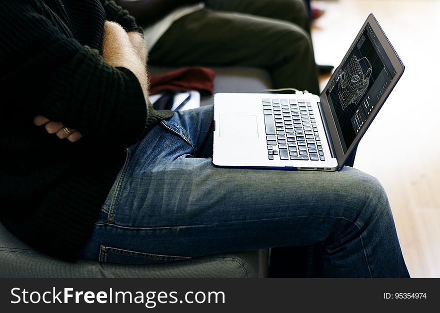 A close up of a laptop in the man's lap. A close up of a laptop in the man's lap.