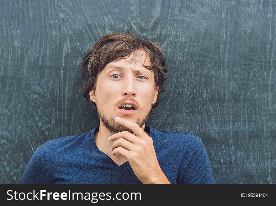 Top view of a young man with space for text and symbols on the old wooden background. Concept for confusion, brainstorming and choice.