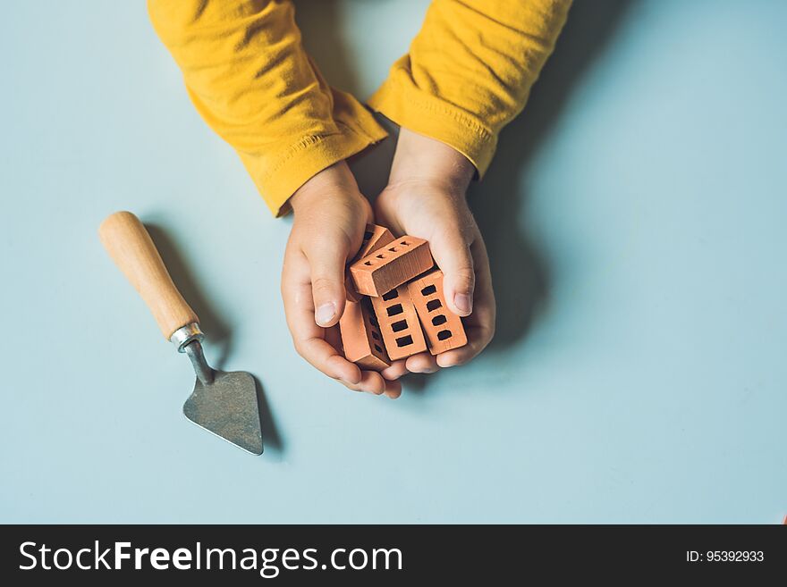 Close Up Of Child`s Hands Playing With Real Small Clay Bricks At