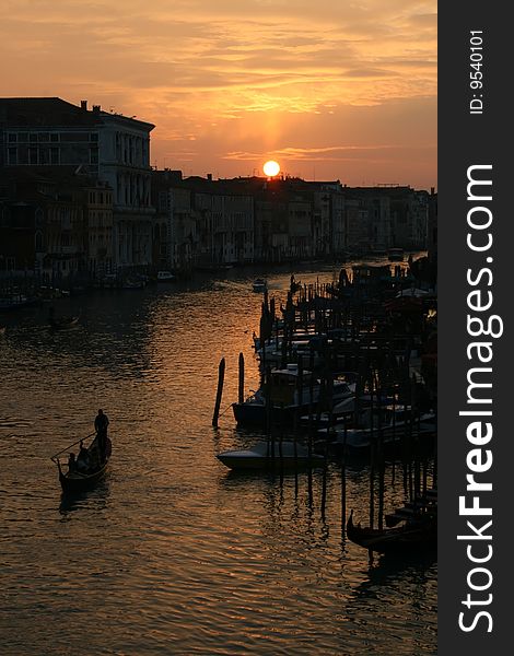 Silhouetted gondolier at sunset on the Grand Canal in Venice