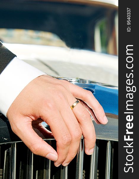 Male wedding ring with a fancy Buick as backdrop.
