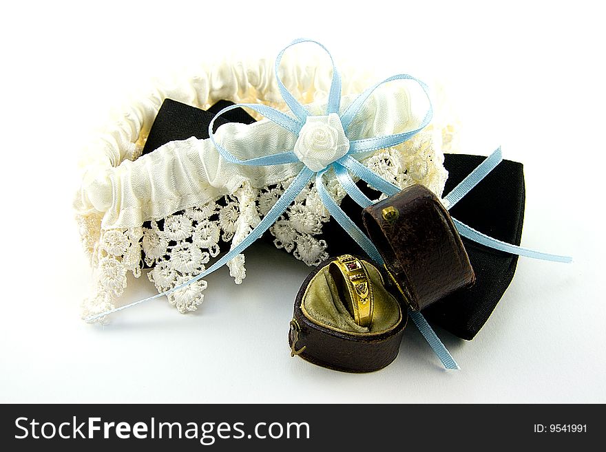 Black bow tie with lace garterand gold ring in a box on a white background. Black bow tie with lace garterand gold ring in a box on a white background